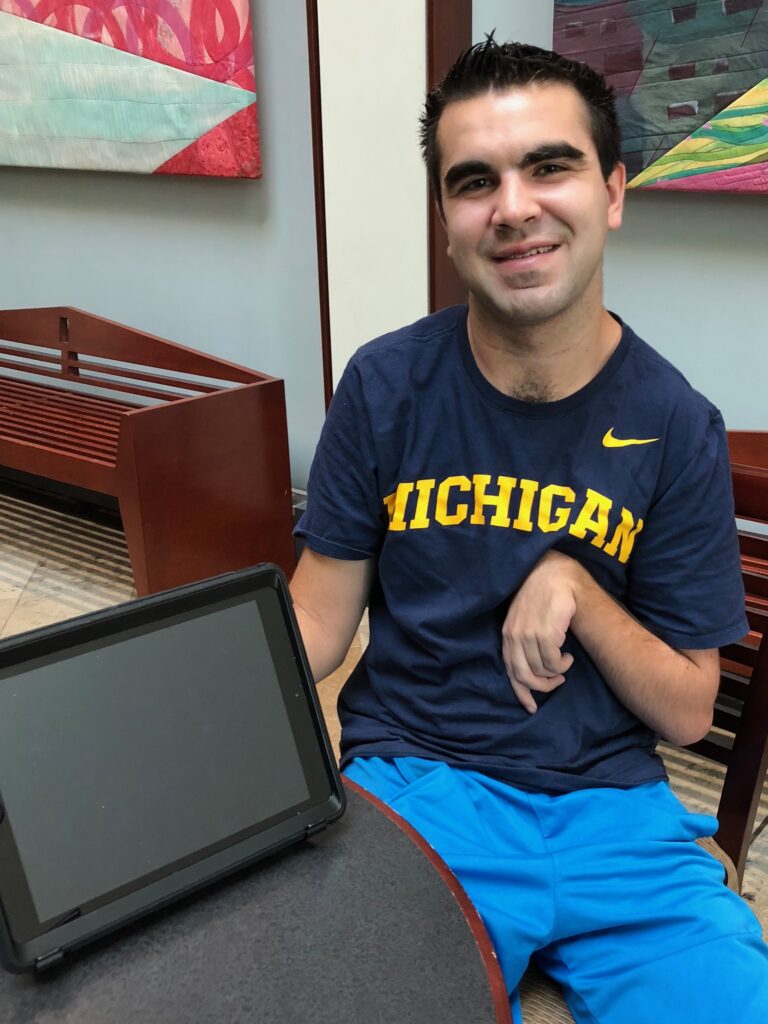 Man posing for a photo with an iPad.