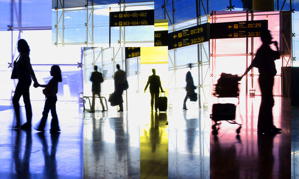 Air Travel shadows of people inside an airline terminal with suitcases and departure signs