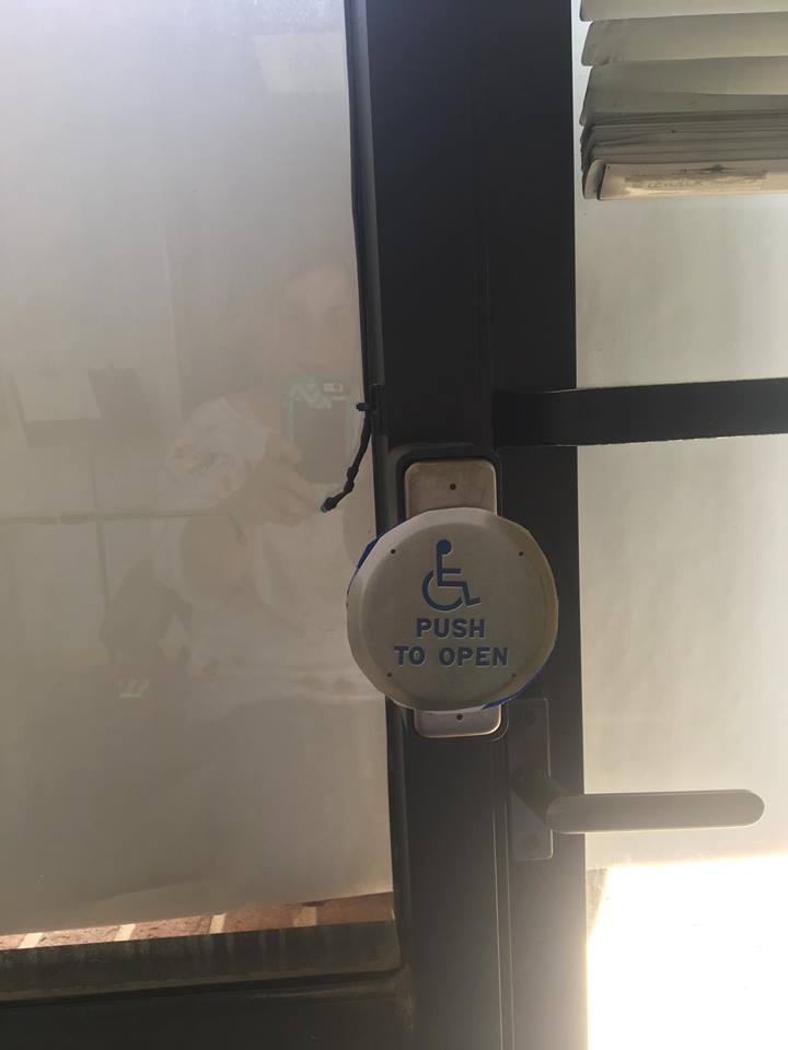 Round accessible power door button pasted over a smaller rectangular button